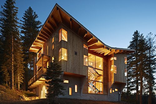 Contemporary wood mountain home lit up at night - Jumbo Loans